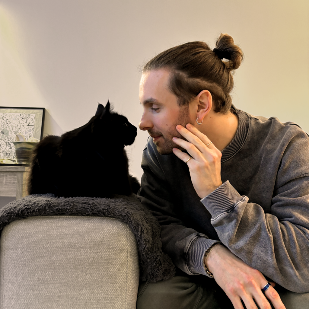 Joffrey nez à nez avec son chat noir sur le canapé